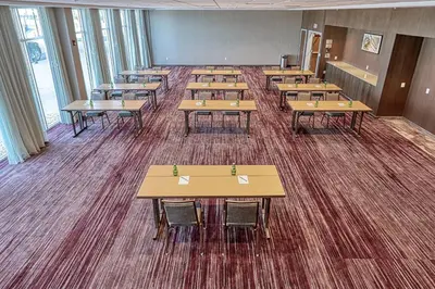 a classroom with tables and chairs in a room at Courtyard by Marriott North Brunswick in North Brunswick