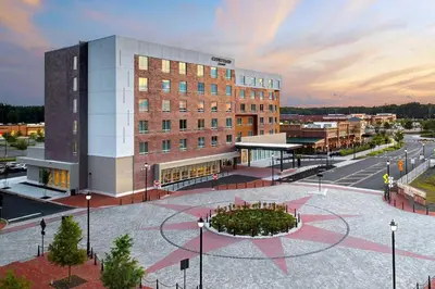 a rendering of a building with a clock in front of it at Courtyard by Marriott North Brunswick in North Brunswick
