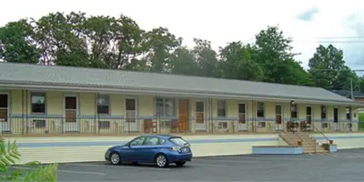 a blue car parked in front of a building at Budget Host Inn in New Berlinville