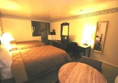 a hotel room with two beds and a desk at Budget Host Inn in New Berlinville