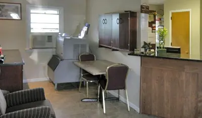 a kitchen with a counter and a table and chairs at Budget Host Inn in New Berlinville