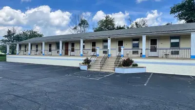 an empty parking lot in front of a building at Budget Host Inn in New Berlinville