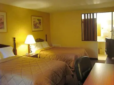 a hotel room with two beds and a window at Budget Host Inn in New Berlinville
