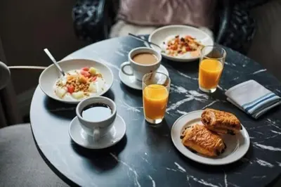 a table topped with plates of breakfast foods and orange juice at The Frederick Hotel Tribeca in New York