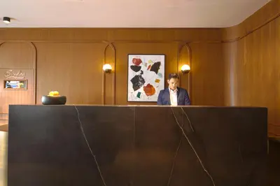 a man sitting at a desk in a room at The Frederick Hotel Tribeca in New York