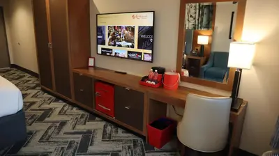 a hotel room with a desk and a television at Resorts World Catskills in Monticello
