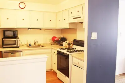 a kitchen with white cabinets and a stove top oven at Artist in the Barn in Philadelphia