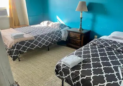 a bedroom with two beds and a blue wall at Artist in the Barn in Philadelphia