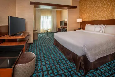 a hotel room with a bed and a flat screen tv at Fairfield Inn & Suites by Marriott Harrisburg International Airport in Middletown