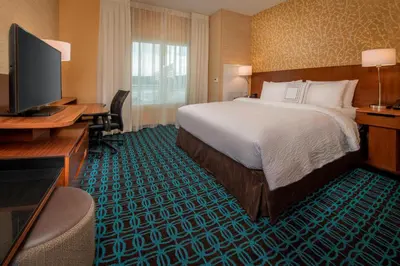 a hotel room with a bed and a desk and a television at Fairfield Inn & Suites by Marriott Harrisburg International Airport in Middletown