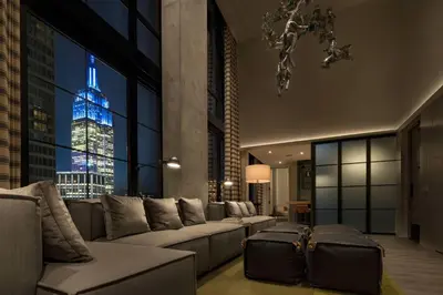 a living room with a couch and a view of a building at Moxy NYC Chelsea in New York