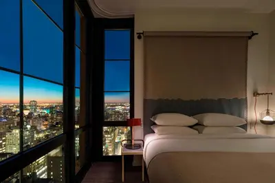 a bedroom with a bed and a view of a city at Moxy NYC Chelsea in New York