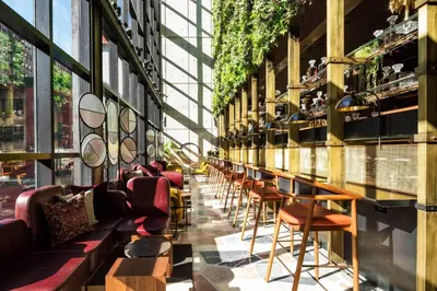 a row of chairs and tables in a building with windows at Moxy NYC Chelsea in New York