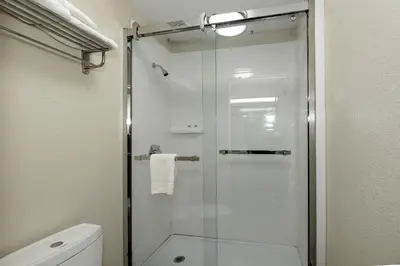 a bathroom with a glass shower with a toilet at Red Roof Inn Freehold in Freehold