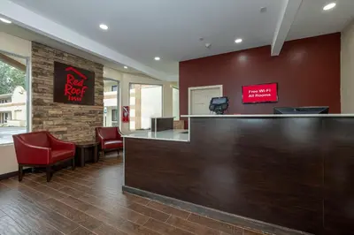 a bar in a waiting room with red chairs at Red Roof Inn Freehold in Freehold