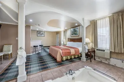 a hotel room with a bed and a tub at Knights Inn Trevose in Trevose