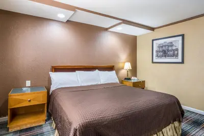 a hotel room with a bed and two night stands at Knights Inn Trevose in Trevose