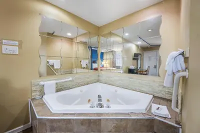 a bathroom with a tub and a large mirror at Knights Inn Trevose in Trevose