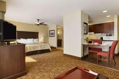 a hotel room with a bed and a desk with a tv at Homewood Suites by Hilton Binghamton/Vestal in Vestal