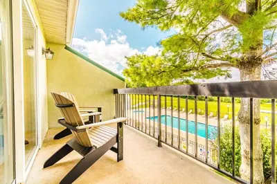 a balcony with a chair and a swimming pool at Hershey Farm Resort in Ronks