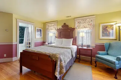 a bedroom with a bed and a blue chair at After Eight Bed and Breakfast in Ronks