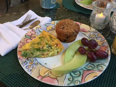 a plate of food with a muffin and fruit on a table at After Eight Bed and Breakfast in Ronks