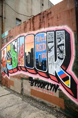 a wall covered in graffiti on the side of a building at The Lodge Red Hook in Brooklyn