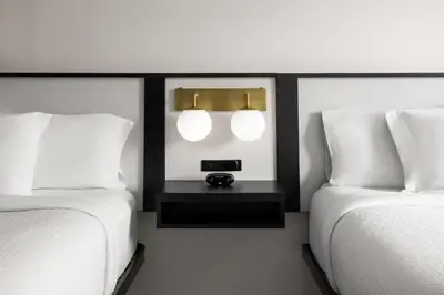 two beds in a hotel room with two lamps between them at Ramada by Wyndham York Harrisburg Hershey in York