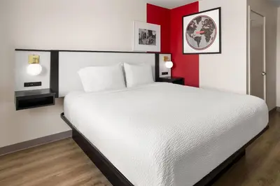 a bedroom with a white bed and red walls at Ramada by Wyndham York Harrisburg Hershey in York