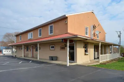 a building with a parking lot in front of it at Red Carpet Inn Ronks in Ronks