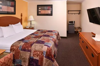 a hotel room with a bed and a flat screen tv at Red Carpet Inn Ronks in Ronks