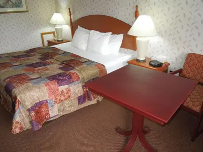 a hotel room with a bed and a wooden table at Red Carpet Inn Ronks in Ronks
