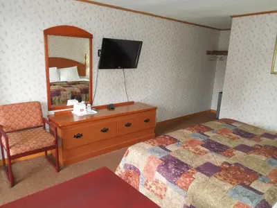 a bedroom with a bed and a mirror and a chair at Red Carpet Inn Ronks in Ronks