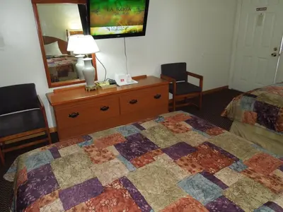 a hotel room with a bed and a dresser and a mirror at Red Carpet Inn Ronks in Ronks