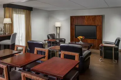 a room with tables and chairs and a flat screen tv at Sheraton Great Valley Hotel in Frazer