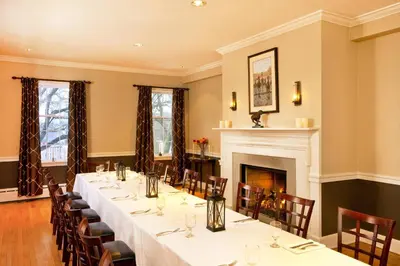 a dining room with tables and chairs and a fireplace at Sheraton Great Valley Hotel in Frazer