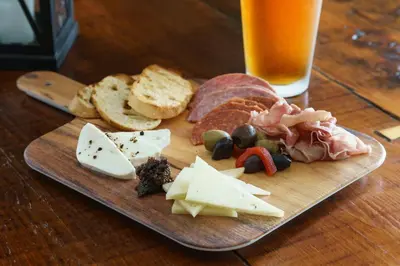a plate of cheese and meats and bread and a glass of beer at Sheraton Great Valley Hotel in Frazer