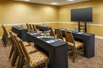 a conference room with tables and chairs and a flat screen tv at Sheraton Great Valley Hotel in Frazer