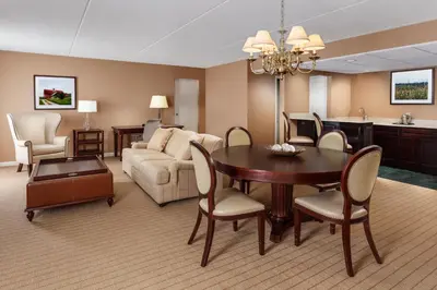 a living room with a dining room table and a couch at Sheraton Great Valley Hotel in Frazer