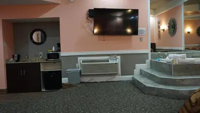 a hotel room with stairs and a television on the wall at Inn of the Dove Cherry Hill - Philadelphia in Cherry Hill