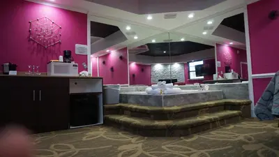 a bathroom with a large tub and pink walls at Inn of the Dove Cherry Hill - Philadelphia in Cherry Hill
