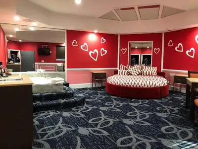 a hotel room with two beds and red walls at Inn of the Dove Cherry Hill - Philadelphia in Cherry Hill