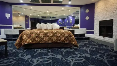 a hotel room with a bed and a fireplace at Inn of the Dove Cherry Hill - Philadelphia in Cherry Hill
