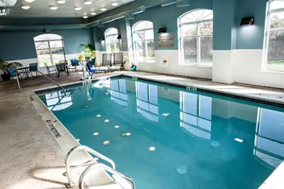 a swimming pool in a room with blue walls and windows at Country Inn & Suites by Radisson, Harrisburg West Mechanicsburg in Mechanicsburg