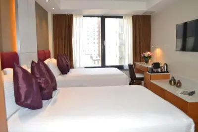 a hotel room with two beds and a desk at Concorde Hotel New York in New York