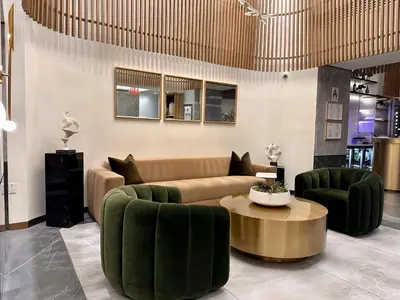 a living room with a couch and green chairs at Concorde Hotel New York in New York