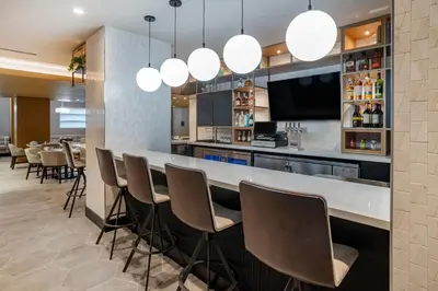a bar in a restaurant with chairs and a tv at Sheraton Suites Wilmington Downtown in Wilmington