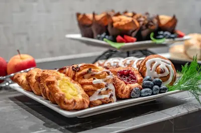 a plate of pastries and fruit on a table at Sheraton Suites Wilmington Downtown in Wilmington