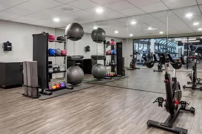a gym with tread machines and a mirror at Sheraton Suites Wilmington Downtown in Wilmington