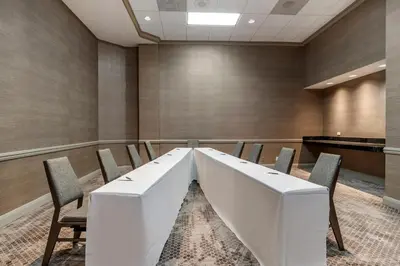 a conference room with a white table and chairs at Sheraton Suites Wilmington Downtown in Wilmington